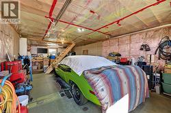 Expansive garage space featuring exposed wood framing, ceiling insulation, and a built-in wooden staircase - 