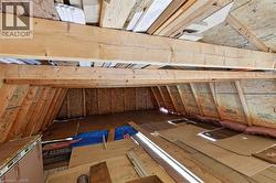 Unfinished attic space featuring exposed wood framing, oriented strand board walls, and visible insulation - 