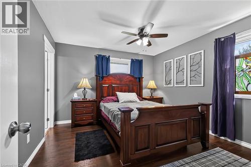 Spacious room featuring wood-finish flooring, a ceiling fan with integrated lighting, and multiple windows - 184726 Cornell Road, Tillsonburg, ON - Indoor Photo Showing Bedroom