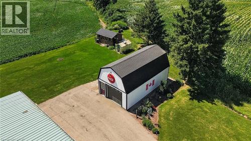 Spacious barn with a black shingled roof, white siding, and a large roll-up door - 184726 Cornell Road, Tillsonburg, ON - Outdoor