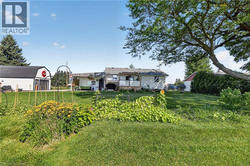 Expansive green lawn with mature trees and established garden beds - 184726 Cornell Road, Tillsonburg, ON - Outdoor