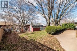 Fenced backyard featuring a storage shed - 