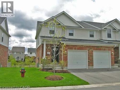 Two-story residence featuring brick and siding exterior, a covered front entry with columns, and an integrated two-car garage - 151 Clairfields Drive E Unit# 39, Guelph, ON - Outdoor