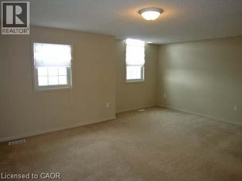 Spacious room featuring neutral carpeting and light-toned wall paint - 151 Clairfields Drive E Unit# 39, Guelph, ON - Indoor Photo Showing Other Room