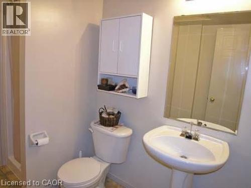 Pedestal sink with chrome fixtures, an overhead vanity light fixture, and a wall-mounted mirror - 151 Clairfields Drive E Unit# 39, Guelph, ON - Indoor Photo Showing Bathroom