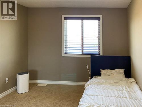 Room featuring a single window with white trim and horizontal blinds, neutral wall paint, white baseboards, and carpeted flooring - 180 Huck Crescent, Kitchener, ON - Indoor Photo Showing Bedroom