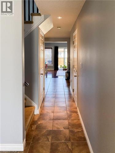 Inviting hallway featuring neutral wall tones and square tile flooring - 180 Huck Crescent, Kitchener, ON - Indoor Photo Showing Other Room