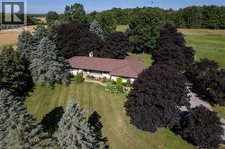 Ranch-style residence on an expansive lot with mature trees and a gravel driveway - 