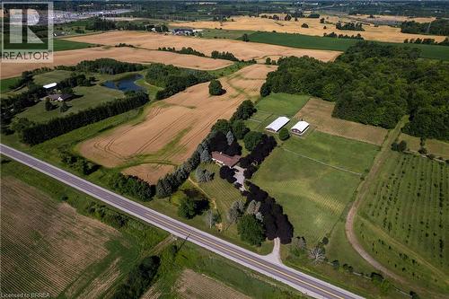 Expansive rural property featuring a main residence, cultivated fields, wooded areas, two white outbuildings, and a pond - 269 Brant County Road 22, Ancaster, ON - Outdoor With View
