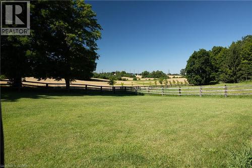 Expansive grassy area featuring a split-rail fence, mature trees, and a distant field - 269 Brant County Road 22, Ancaster, ON - Outdoor With View