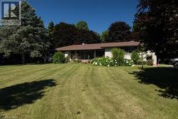 Single-story exterior with light-toned siding and a brown shingle roof - 