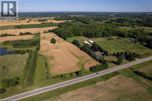 Expansive rural property featuring cultivated fields, mature tree lines, a private pond, and multiple outbuildings - 269 Brant County Road 22, Ancaster, ON - Outdoor With View