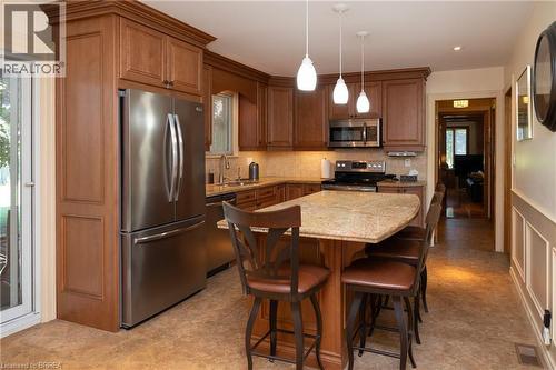 Kitchen featuring wood cabinetry, stainless steel appliances, a stone countertop island, tile flooring, and pendant lighting - 269 Brant County Road 22, Ancaster, ON - Indoor Photo Showing Other Room