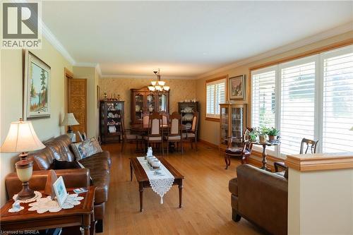 Open-concept living and dining areas featuring wood-finish flooring, white crown molding, and plantation shutters - 269 Brant County Road 22, Ancaster, ON - Indoor Photo Showing Living Room