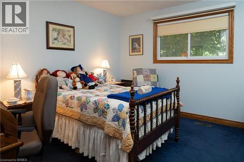 Bedroom featuring light blue walls, wood-trimmed window, and blue carpet - 269 Brant County Road 22, Ancaster, ON - Indoor Photo Showing Bedroom