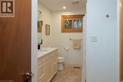 Bathroom featuring a cream-colored vanity with a light-toned countertop, a rectangular undermount sink, and a framed mirror - 