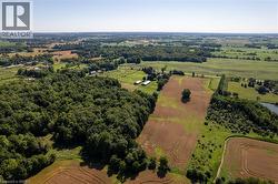 Expansive rural landscape featuring a mix of mature woodlands and cultivated fields - 