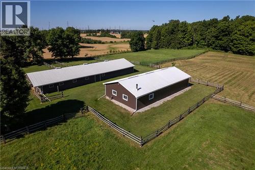 Two dark-toned outbuildings with metal roofs, surrounded by fenced green pastures - 269 Brant County Road 22, Ancaster, ON - Outdoor With View