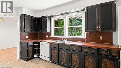 Kitchen featuring black cabinetry, wood-finish countertops, and a double basin sink beneath a large window - 524 Dorval Drive, Ancaster, ON - Indoor Photo Showing Other Room