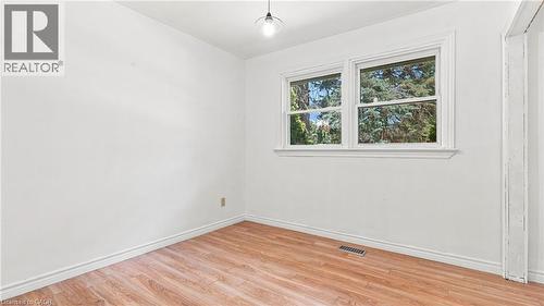 Bright room featuring dual windows with white trim, wood-finish flooring, and white baseboards - 524 Dorval Drive, Ancaster, ON - Indoor Photo Showing Other Room