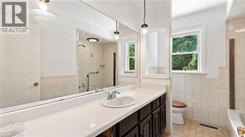 Bathroom vanity featuring a single basin, chrome faucet, and expansive wall-mounted mirror - 524 Dorval Drive, Ancaster, ON - Indoor Photo Showing Bathroom