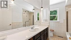 Bathroom vanity featuring a single basin, chrome faucet, and expansive wall-mounted mirror - 