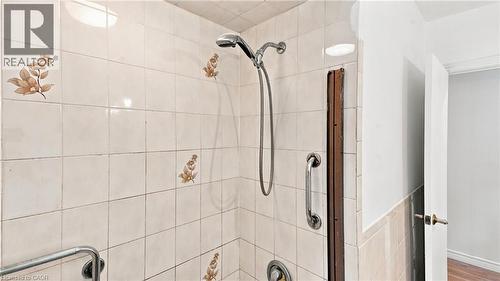 Tiled shower with handheld shower fixture and chrome grab bars - 524 Dorval Drive, Ancaster, ON - Indoor Photo Showing Bathroom
