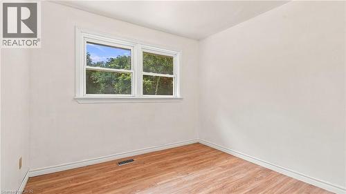Room featuring light-colored walls, wood-finish flooring, white baseboards, and a white-framed window - 524 Dorval Drive, Ancaster, ON - Indoor Photo Showing Other Room