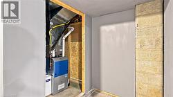 Dedicated utility area featuring a modern furnace unit with associated ductwork and piping - 