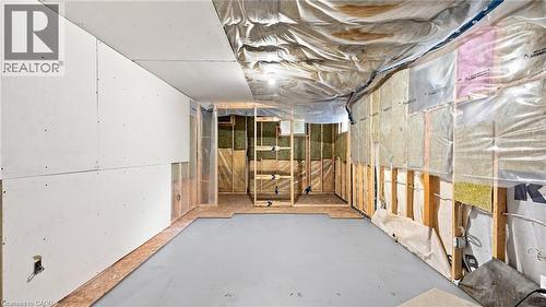 Unfinished basement space with exposed wood framing, partial drywall installation, and visible insulation - 524 Dorval Drive, Ancaster, ON - Indoor Photo Showing Basement