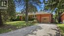 Brick-clad exterior featuring an attached garage, paved driveway, mature trees, and a front lawn - 524 Dorval Drive, Ancaster, ON  - Outdoor 
