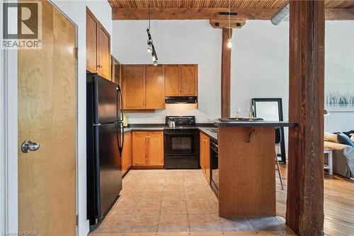 Kitchen featuring a black appliance suite, light wood-finish cabinetry, and a dark countertop - 26 Ontario Street Unit# 127, Guelph, ON - Indoor Photo Showing Kitchen