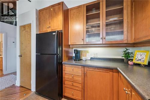 Black refrigerator complementing wood-finish cabinetry - 26 Ontario Street Unit# 127, Guelph, ON - Indoor Photo Showing Kitchen