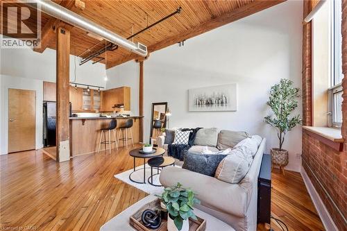 Open-concept living space featuring exposed wood beams, high wood plank ceilings, and polished wood flooring - 26 Ontario Street Unit# 127, Guelph, ON - Indoor Photo Showing Living Room