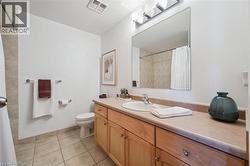 Bathroom featuring a single vanity with wood-finish cabinetry, a large mirror, and a shower-tub combination - 