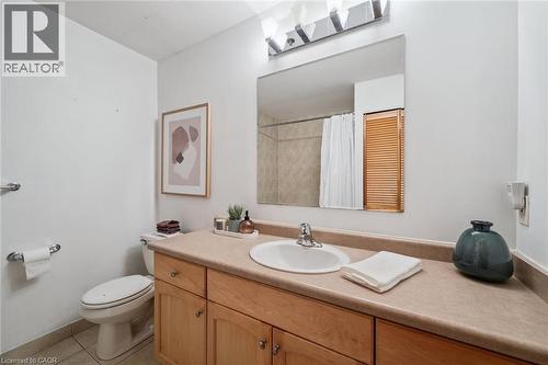 Bathroom vanity with light wood-finish cabinetry, a single basin sink, and a light-toned countertop - 26 Ontario Street Unit# 127, Guelph, ON - Indoor Photo Showing Bathroom