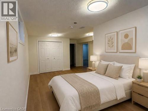 Spacious room featuring wood-finish flooring, white walls, and a large bi-fold closet - 248 Cyrus Street, Cambridge, ON - Indoor Photo Showing Bedroom