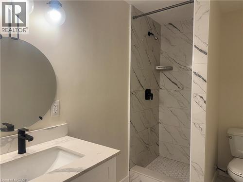 Bathroom featuring a walk-in shower with large format marble-look tile walls and a hexagonal tile floor - 248 Cyrus Street, Cambridge, ON - Indoor Photo Showing Bathroom