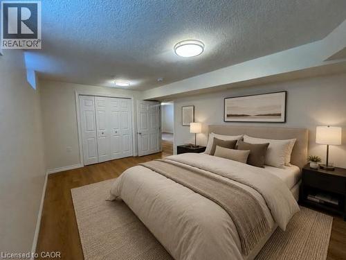 Bedroom featuring wood-finish flooring, two sets of bi-fold closet doors, a neutral wall color, and flush-mount ceiling lighting - 248 Cyrus Street, Cambridge, ON - Indoor Photo Showing Bedroom