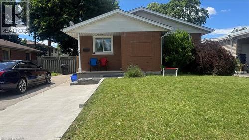 Brick-front residence with a concrete driveway, mature landscaping, a covered front porch, and a well-maintained front lawn - 248 Cyrus Street, Cambridge, ON - Outdoor