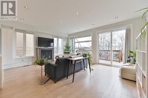 Family room with w/o to deck + cozy gas fireplace - 69 Holmstead Avenue, Toronto, ON - Indoor Photo Showing Living Room With Fireplace