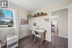 Space featuring wood-finish flooring, a window offering exterior views, and a doorway opening to an additional room - 