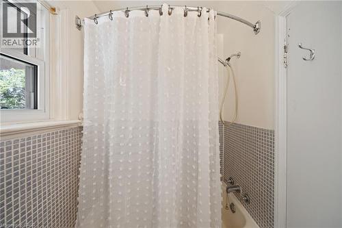 Bathtub with white subway tile surround, hand-held shower fixture, and an operable window - 3 Bousfield Lane, Jarvis, ON - Indoor Photo Showing Bathroom