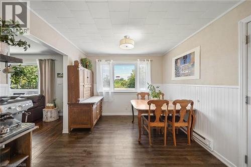 Dining area featuring wood-finish flooring, white beadboard wainscoting, and a ceiling light fixture - 3 Bousfield Lane, Jarvis, ON - Indoor Photo Showing Dining Room
