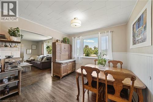 Dining area featuring wood-finish flooring, a large window, a wall-mounted light fixture, and wainscoting - 3 Bousfield Lane, Jarvis, ON - Indoor Photo Showing Dining Room