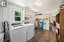 Utility space featuring wood-finish flooring, a window, and built-in shelving - 