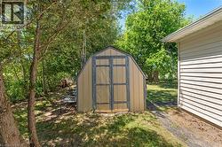 Gable-roof shed featuring double doors and neutral siding - 