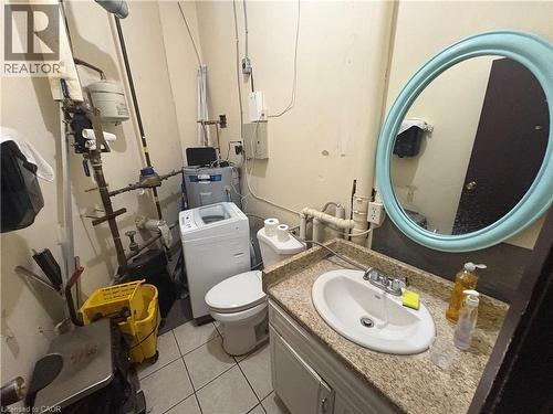 Compact utility space with a built-in vanity featuring a speckled countertop and an oval sink - 209 Lexington Road Unit# F, Waterloo, ON 