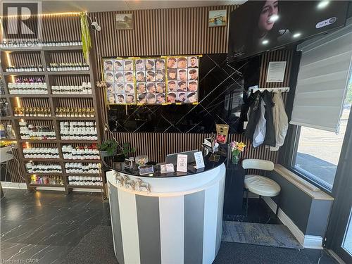 Reception area featuring a curved, striped counter, vertical wood slat wall detailing, and dark large-format tile flooring - 209 Lexington Road Unit# F, Waterloo, ON 