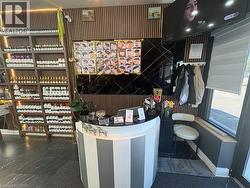 Reception area featuring a curved, striped counter, vertical wood slat wall detailing, and dark large-format tile flooring - 
